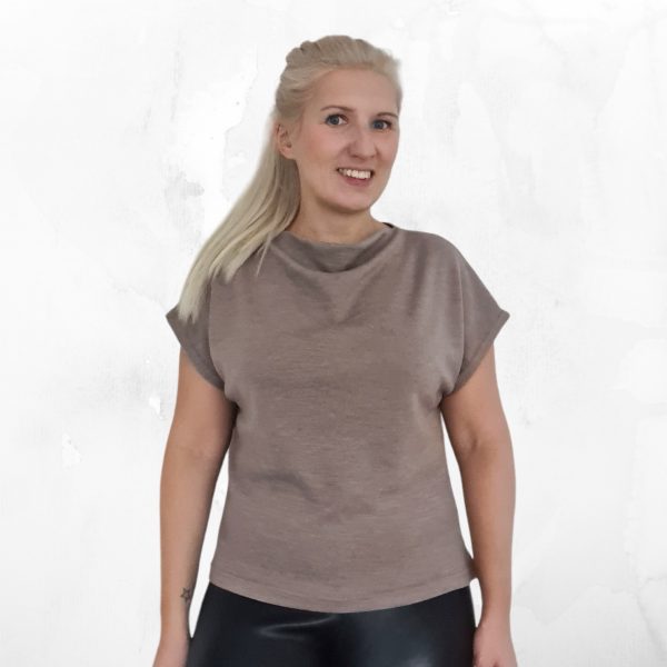 Mallilla on päällä Rina merinovillainen neulepaita sekä Sara neulehame. Paidassa on vesiputouspääntie ja siinä on lyhyet hihat. Vyötärölle on sidottu vyö. Kuvattu edestä.
